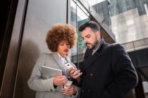 Adult couple with smartphone and tablet at street — Stock Photo