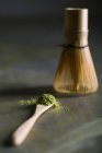 Cuillère en bambou et fouetter avec du thé matcha — Photo de stock