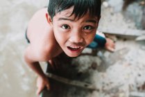LAOS, 4000 ÎLES : Vue du dessus d'un garçon au visage mouillé regardant une caméra — Photo de stock