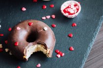 Кусатий шоколадний пончик з начинками на столі — стокове фото