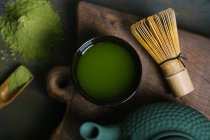 Directly above view of matcha tea in bowl with bamboo whisk — Stock Photo