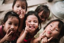 LAOS, 4000 ÎLES : Des enfants mignons font des grimaces drôles et regardent la caméra . — Photo de stock