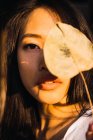 Портрет молодой женщины с сухим листом на закате — стоковое фото