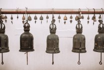 Close up view of bells hanging in row on rack — Stock Photo
