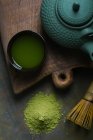 Thé matcha préparé en tasse par pot sur planche à découper — Photo de stock