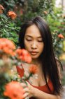 Femme sensuelle posant à la floraison buisson — Photo de stock