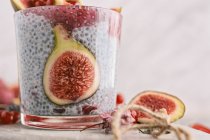 Glass of chia smoothie decorated with currants on stone table — Stock Photo