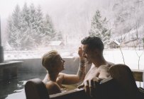 Любящая пара, сидящая в ванне на природе зимой
. — стоковое фото