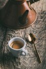 Coffee cup and spoon on rustic wooden table — Stock Photo