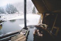 Embracing couple sitting in plunge tub in winter — Stock Photo