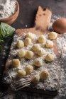Raw gnocchi on wooden cutting board — Stock Photo