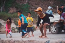LAOS- 18 FÉVRIER 2018 : Un groupe d'enfants asiatiques se moquent des voitures — Photo de stock