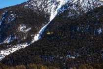 Rescue helicopter flying over mountain landscape — Stock Photo