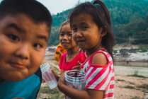 LAOS-FEBRUARY 18, 2018: Cheerful young kids with plastic cups in nature. — Stock Photo