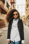 Стильная женщина в солнцезащитных очках ходит по улице — стоковое фото