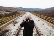 Vista frontal do fotógrafo que visa a via férrea na natureza — Fotografia de Stock