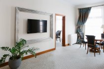 Interior do quarto de hotel de luxo com cadeiras e TV pendurada na parede . — Fotografia de Stock