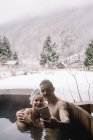 Couple assis dans la baignoire plongeante en hiver — Photo de stock