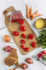 Diretamente acima vista de pimentas vermelhas frescas e outros ingredientes na mesa — Fotografia de Stock