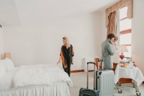 Happy family with child and suitcases in room of hotel. — Stock Photo
