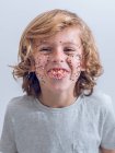 Chico alegre con confeti en la cara - foto de stock