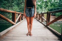 Unterteil der Frau steht auf Holzbrücke — Stockfoto