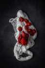 Nature morte poivrons rouges frais au tamis sur le tissu — Photo de stock