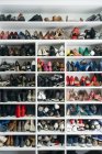 Rack com prateleiras diferentes cheias de variedade de sapatos . — Fotografia de Stock