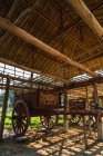 Big vintage wooden wagon parked under roof in village. — Stock Photo