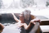 Cheerful topless woman relaxing in outside plunge tub in nature. — Stock Photo