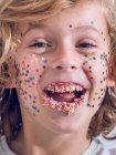 Retrato de menino alegre com confete no rosto — Fotografia de Stock