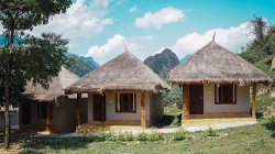 Carino piccoli bungalow con tetti di paglia su prato verde — Foto stock