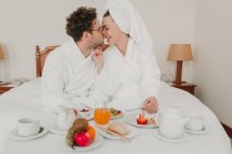 Couple romantique petit déjeuner dans le lit de l'hôtel — Photo de stock