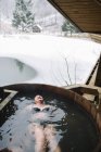 Веселая женщина купается в ванне на открытом воздухе зимой природа
. — стоковое фото
