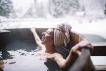 Cheerful topless woman lying in outside plunge tub in nature. — Stock Photo
