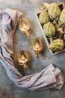 Rusty raw artichokes by crate on table — Stock Photo