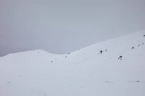 Paisagem nevada de montanhas sobre céu sombrio — Fotografia de Stock