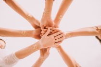From below hands in circle of cheering people with Team Bride words on wrists. — Stock Photo