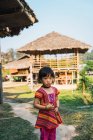 CHIANG RAI, THAILAND- FEBRUARY 12, 2018: Cute young Asian girl standing on street of village in sunny day. — Stock Photo