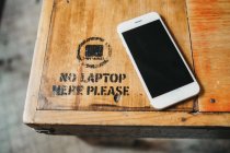 Par dessus smartphone sur table en bois avec panneau d'interdiction pour ordinateur portable . — Photo de stock