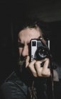 Photographer over black and focusing with vintage camera — Stock Photo