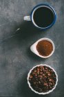 Kaffeetasse mit Kaffeebohnen und gemahlenem Kaffee in Reihe — Stockfoto