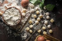 Directly above view of table with raw gnocchi and ingredients on table — Stock Photo