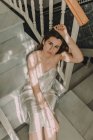 Jovem sensual mulher sentada nas escadas e olhando para a câmera — Fotografia de Stock
