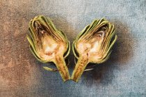 Halves with rusty artichokes over blue vintage background — Stock Photo