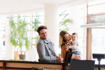 Fröhliche Familie mit Sohn an der Hotelrezeption — Stockfoto