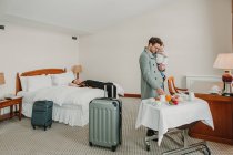 Famiglia giovane con bambino relax in camera d'albergo — Foto stock
