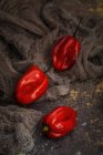 Natureza morta de pimentas vermelhas frescas em tecido rural — Fotografia de Stock