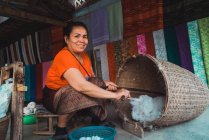 LAOS- 18 FÉVRIER 2018 : Femme souriante travaillant avec du tissu — Photo de stock