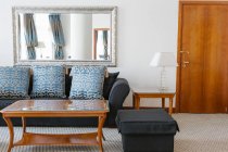 Interno del soggiorno con divano blu e specchio in appartamento
. — Foto stock